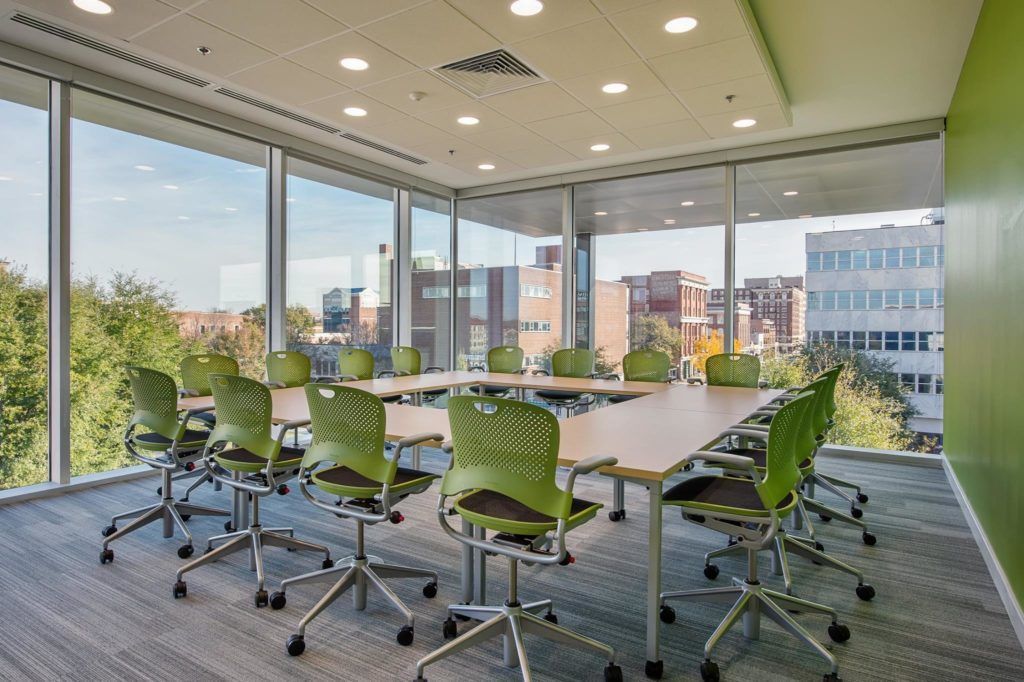 A conference room with tables and chairs and a view of the city.