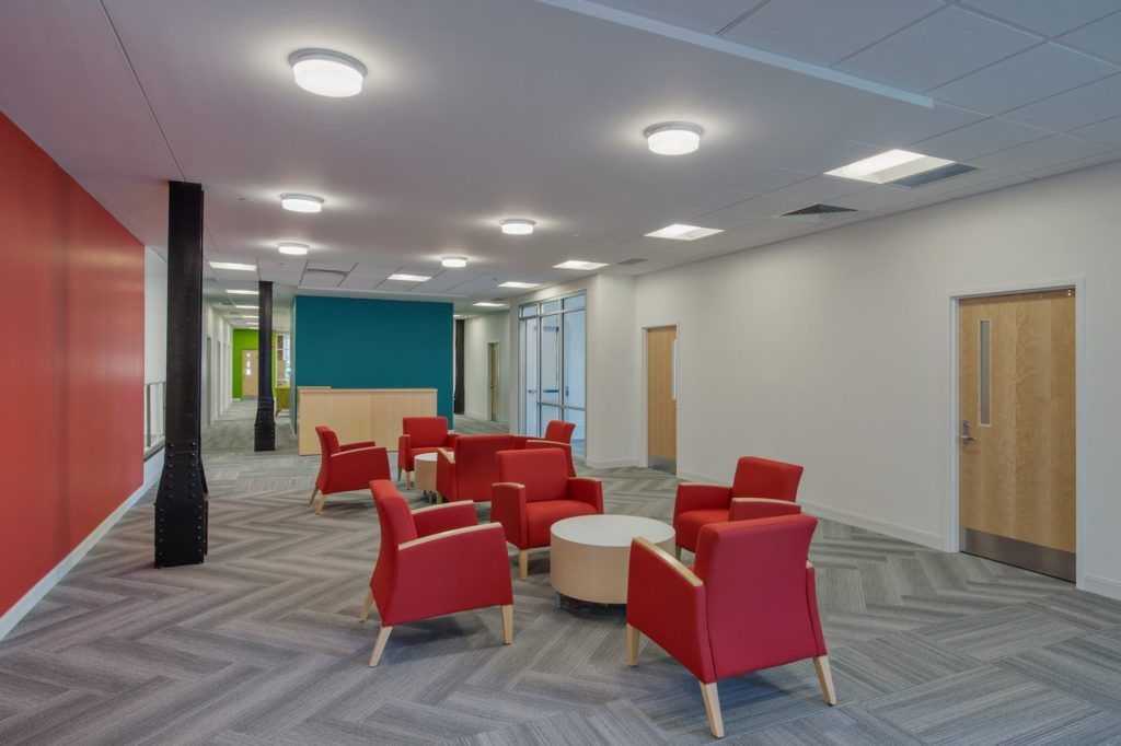 A large room with red chairs and tables in it