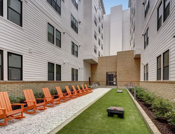 A row of orange chairs are lined up in front of a building.