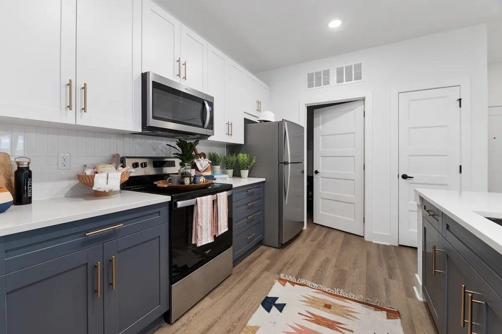 A kitchen with stainless steel appliances and blue cabinets.