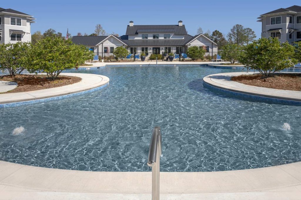 A large swimming pool with a house in the background