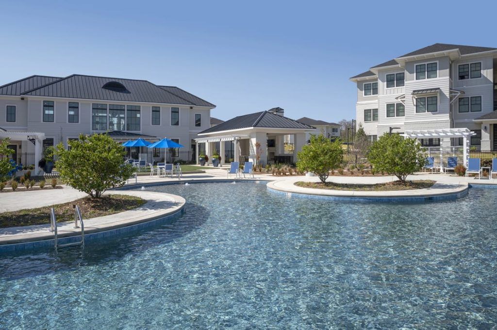 A large swimming pool in front of a large building.