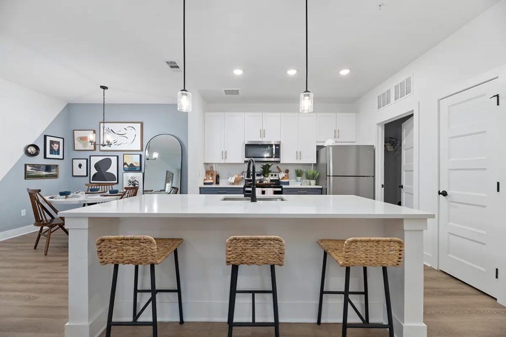 A kitchen with a large island and three stools