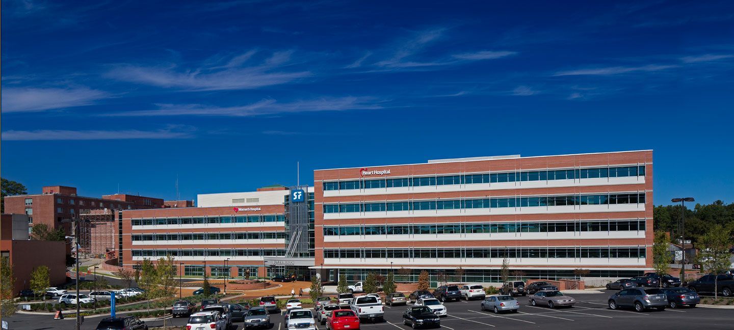 A large building with a lot of cars parked in front of it.