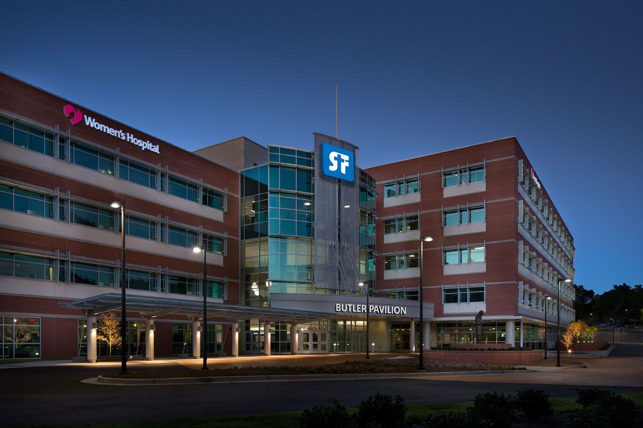 A large brick building with a blue sign that says ' s2 ' on it is lit up at night.