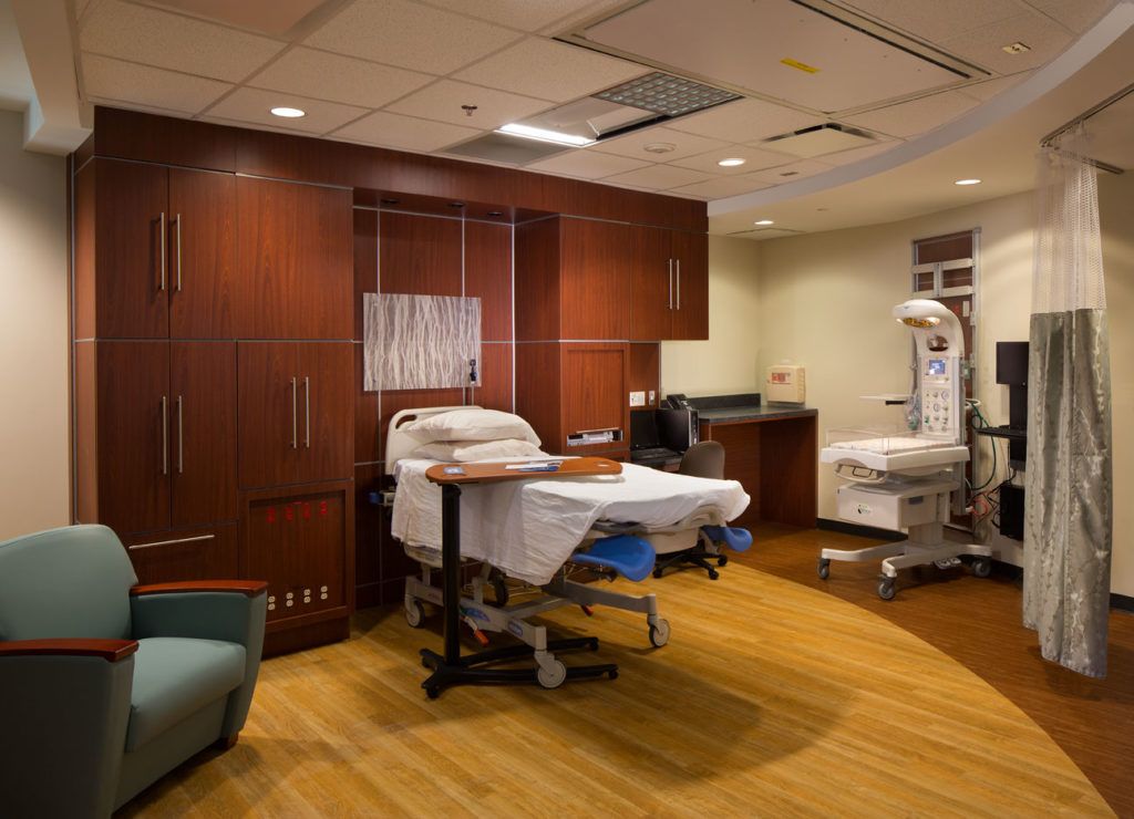 A hospital room with a bed and a chair