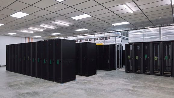 A large room filled with lots of servers in a data center.