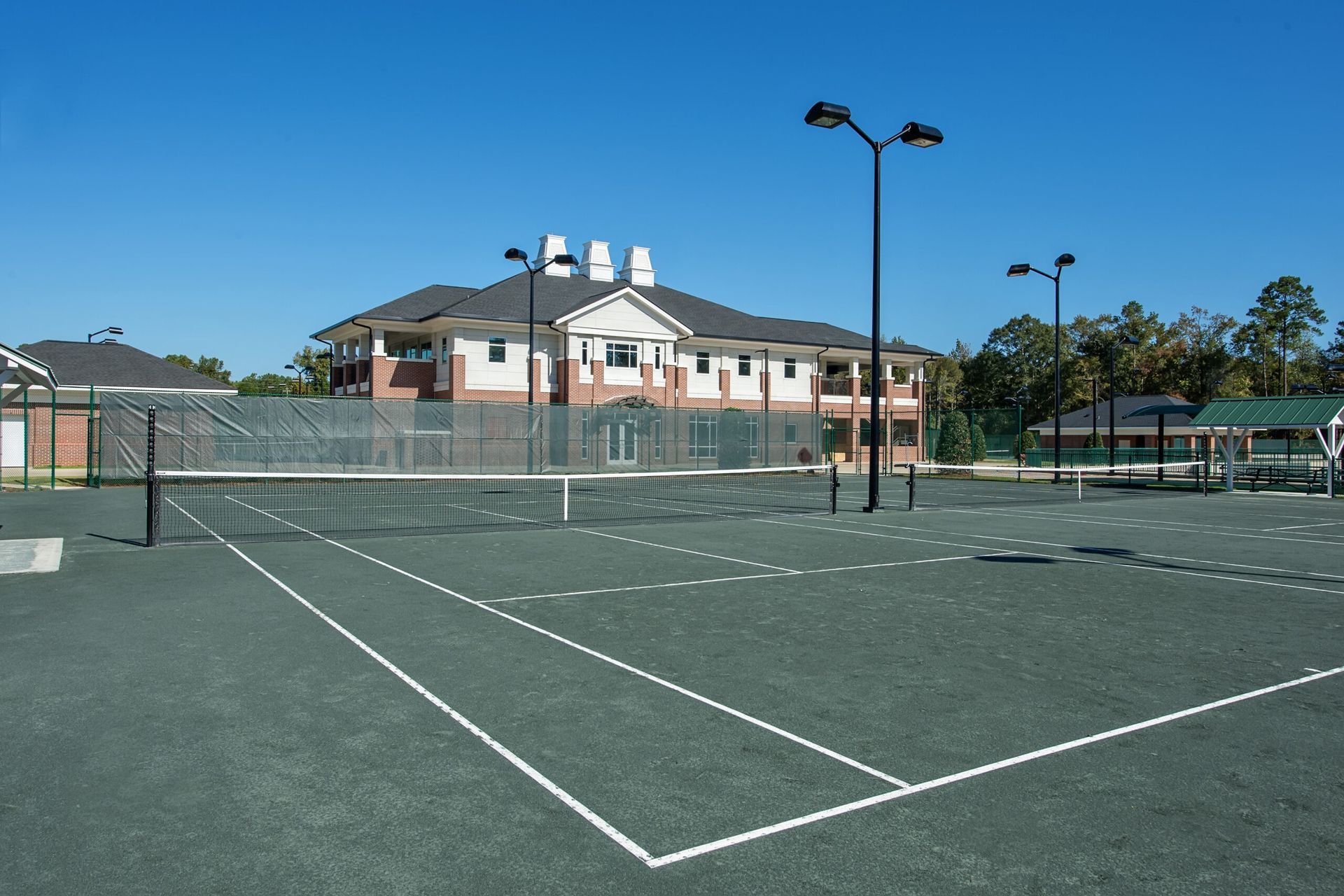 A tennis court with a building in the background