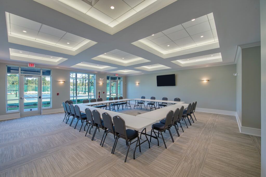 A large conference room with a u shaped table and chairs.