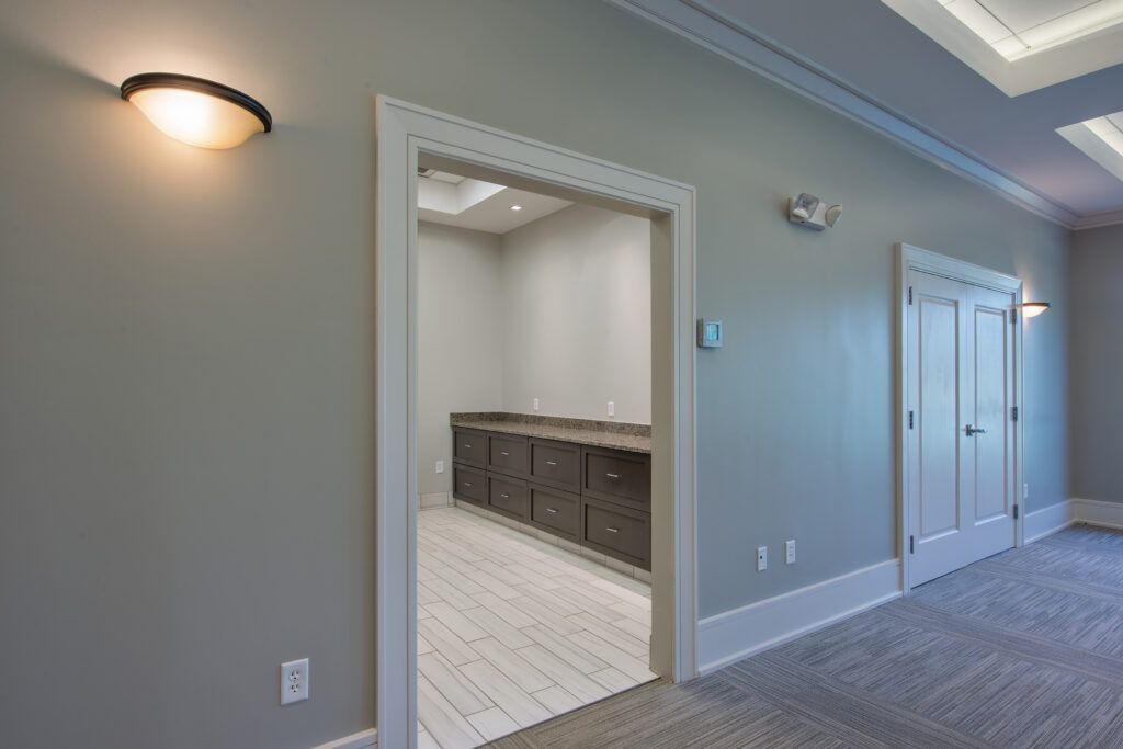 An empty hallway with a doorway leading to a room.