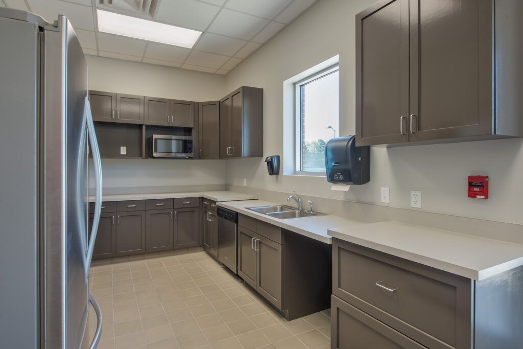 A kitchen with stainless steel appliances and gray cabinets.