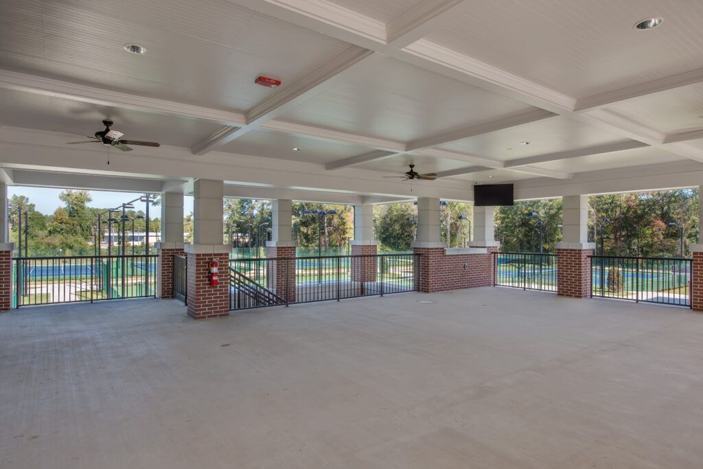 A large empty room with a balcony and a ceiling fan.