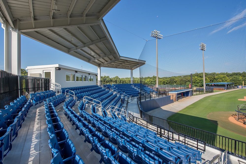 A baseball stadium filled with blue seats and a fence.