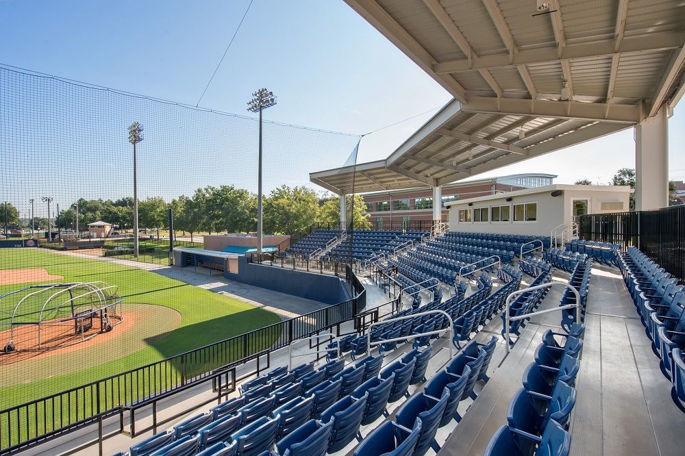 There are rows of blue seats in the stands of a baseball stadium.