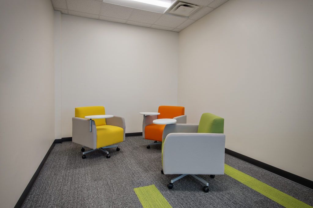 A room with three chairs and a table in it.