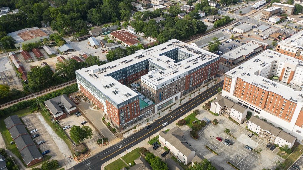 An aerial view of a large apartment building in the middle of a city.