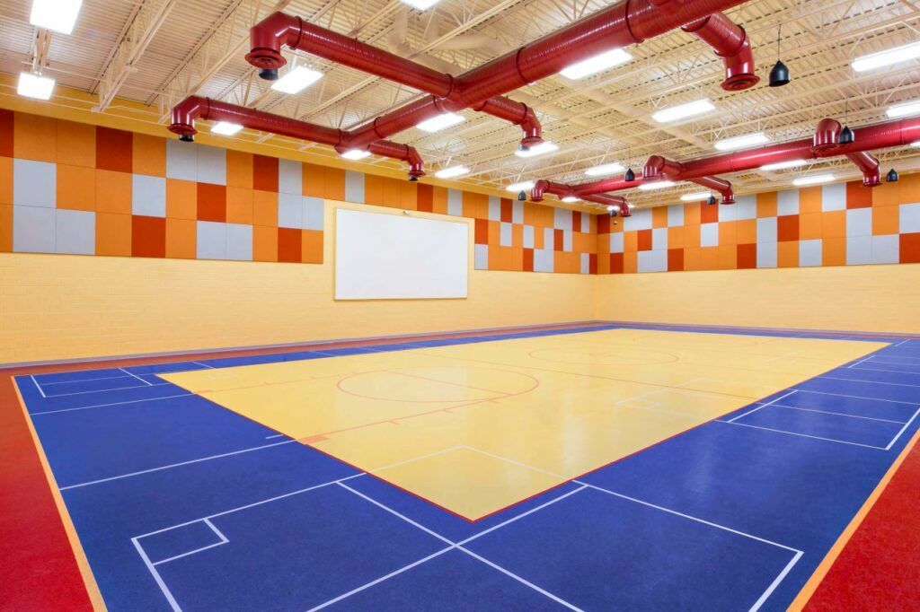 An empty gym with a blue and yellow floor