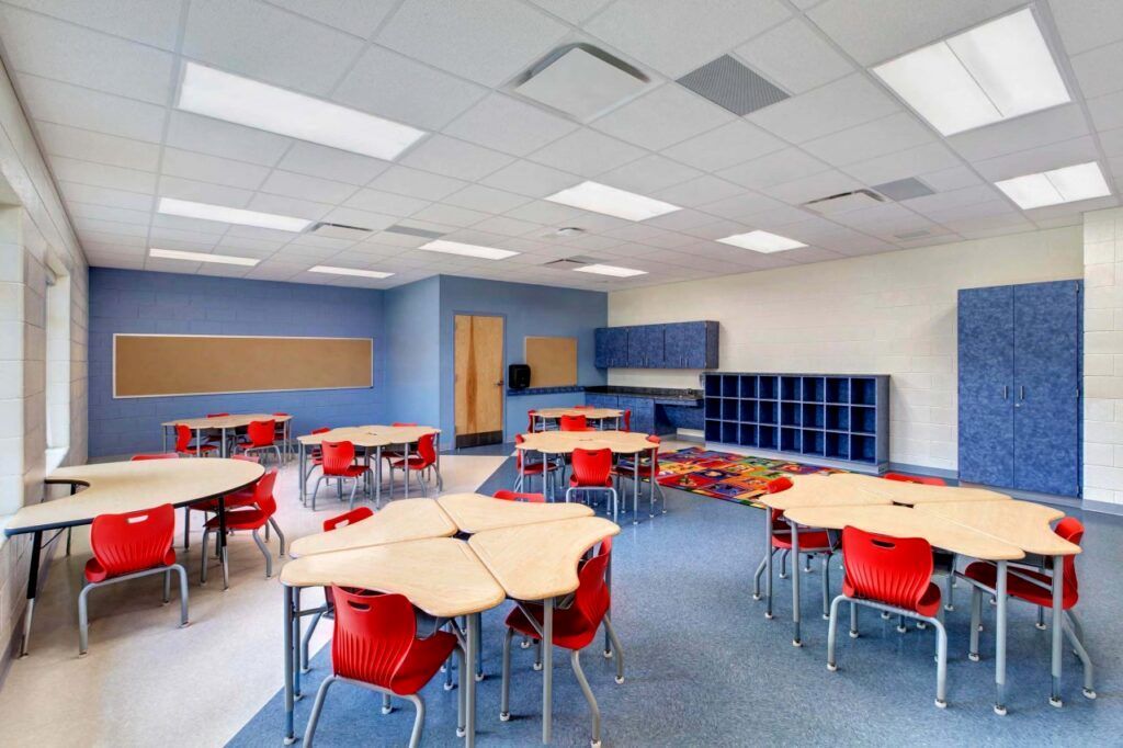 A large classroom with tables and chairs in it