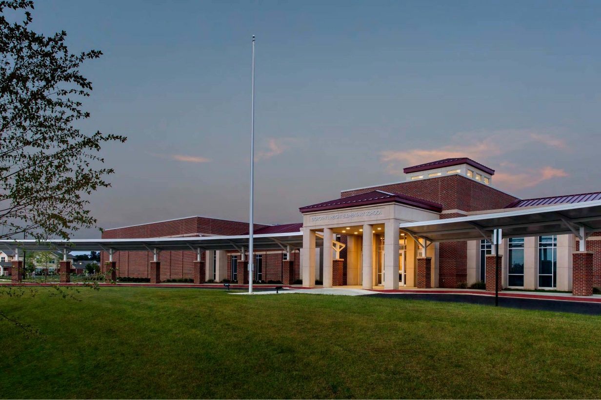 A large brick building with a flag pole in front of it.