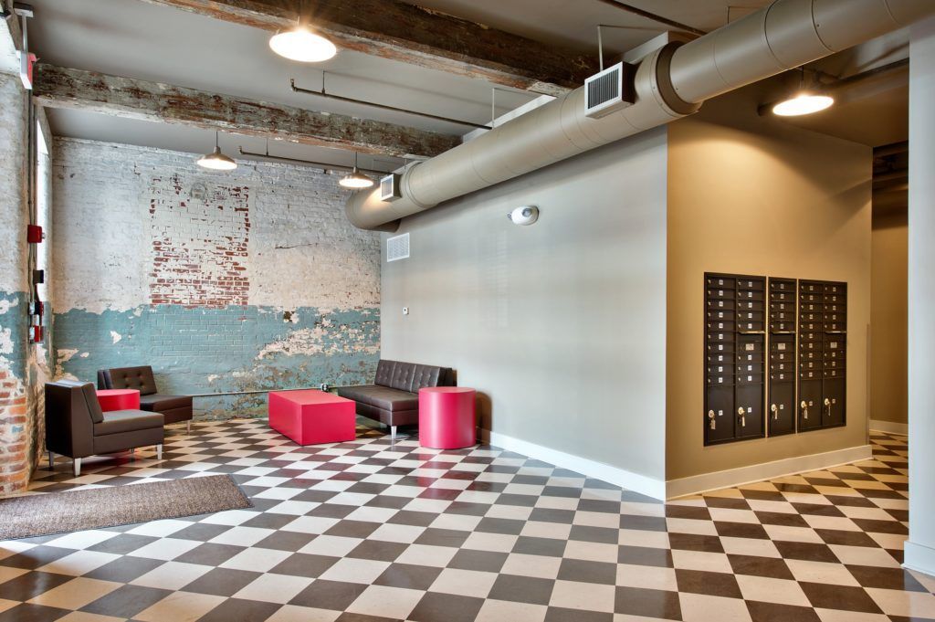 A room with a checkered floor and a brick wall