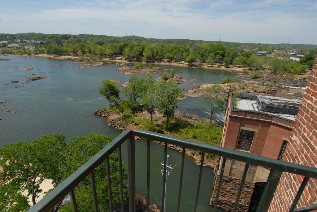 A balcony with a view of a lake and trees