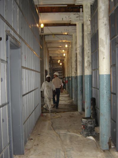 Two men are walking down a long hallway in a building
