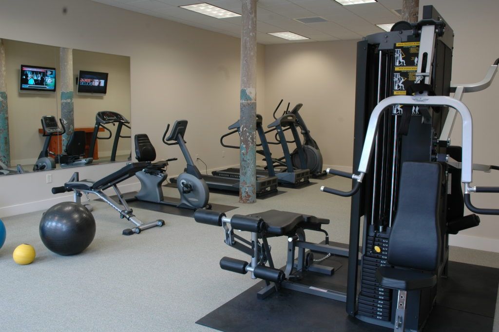 A gym with a lot of equipment and a large mirror