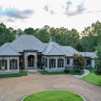 A large house with a gravel driveway leading to it