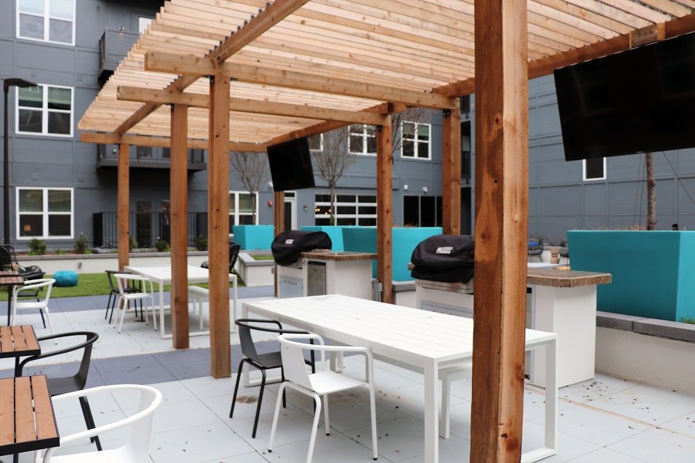 A patio area with tables and chairs under a pergola