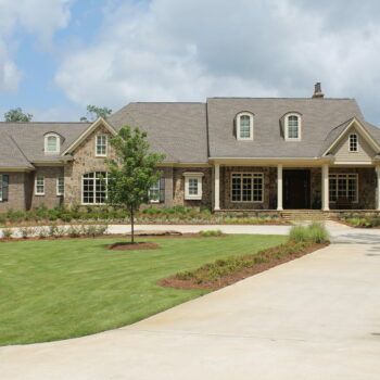 A large brick house with a gray roof and a driveway