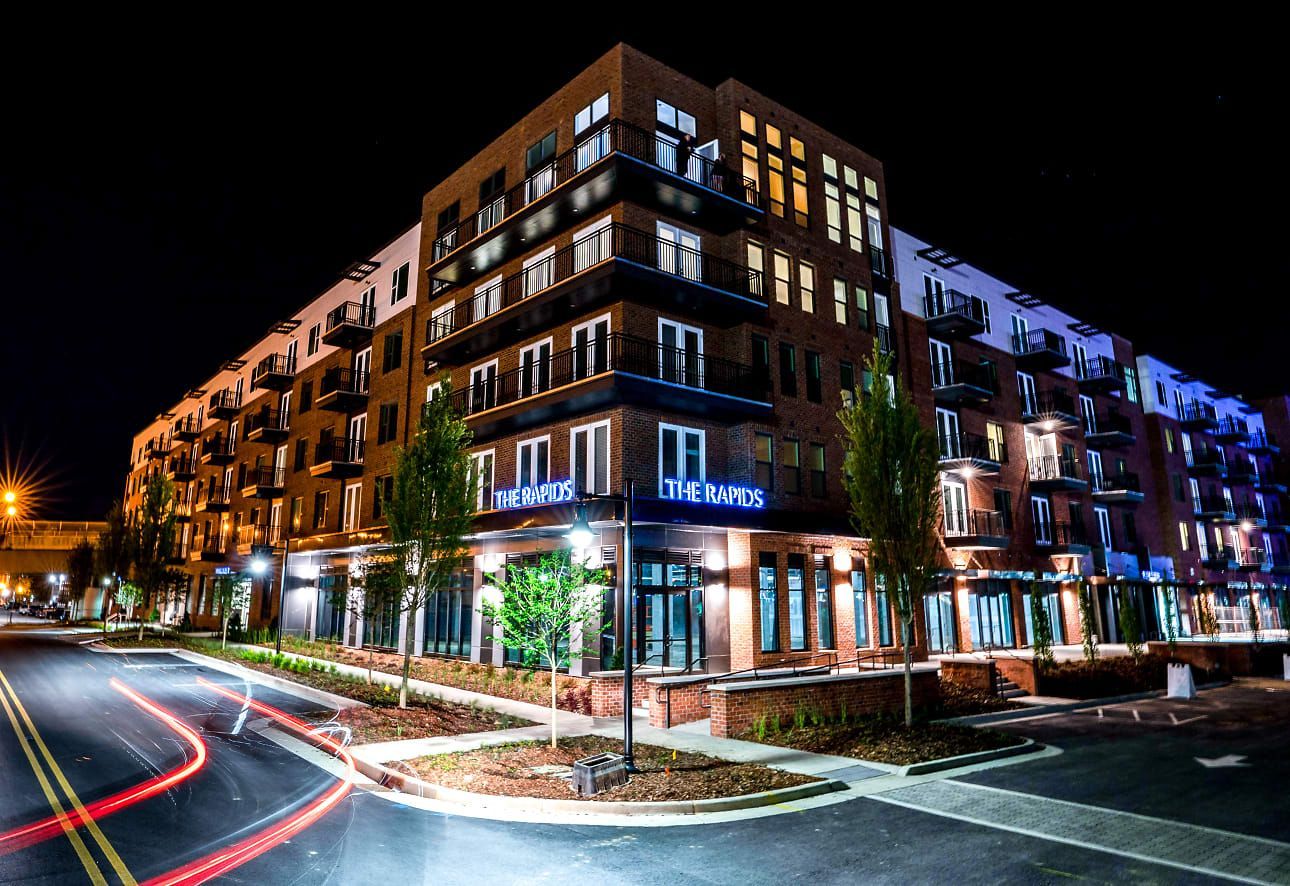 A large building with a lot of windows is lit up at night.