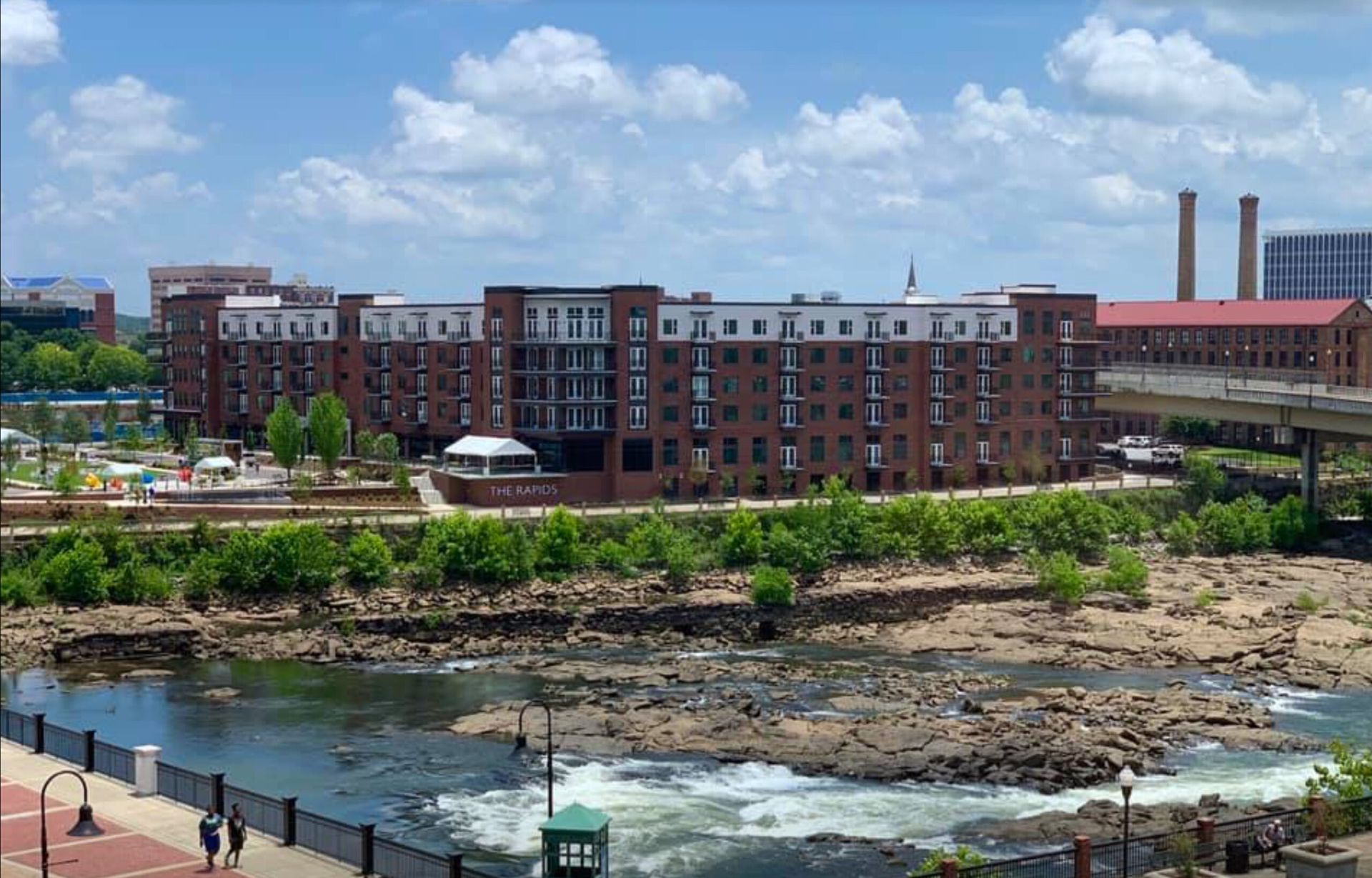 An aerial view of a city with a river in the foreground and a large building in the background.