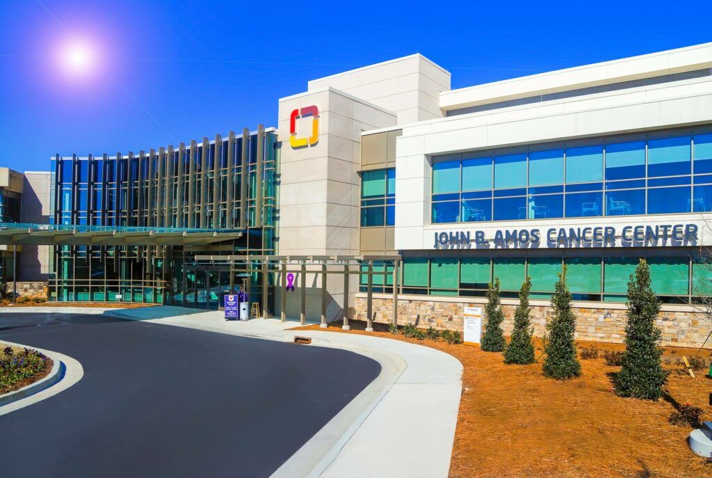 A large building with a lot of windows and trees in front of it.