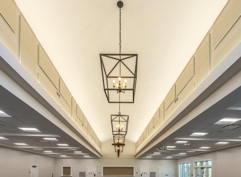 A large room with a ceiling that has a lot of lights hanging from i