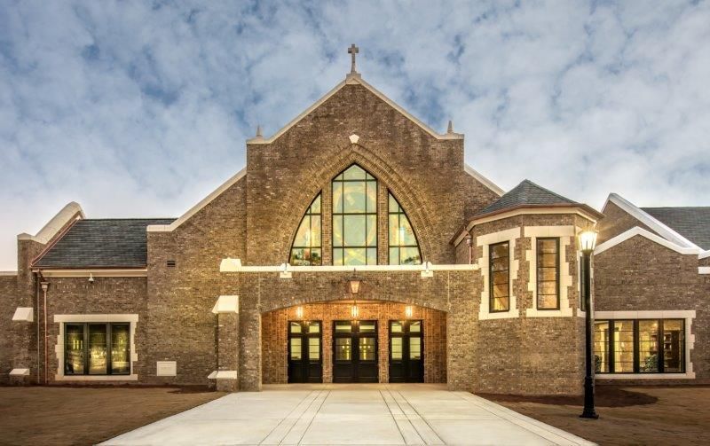 A large brick building with a lot of windows and a street light in front of it.