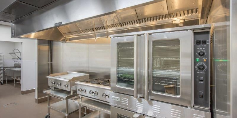 A kitchen with stainless steel appliances and a stove.