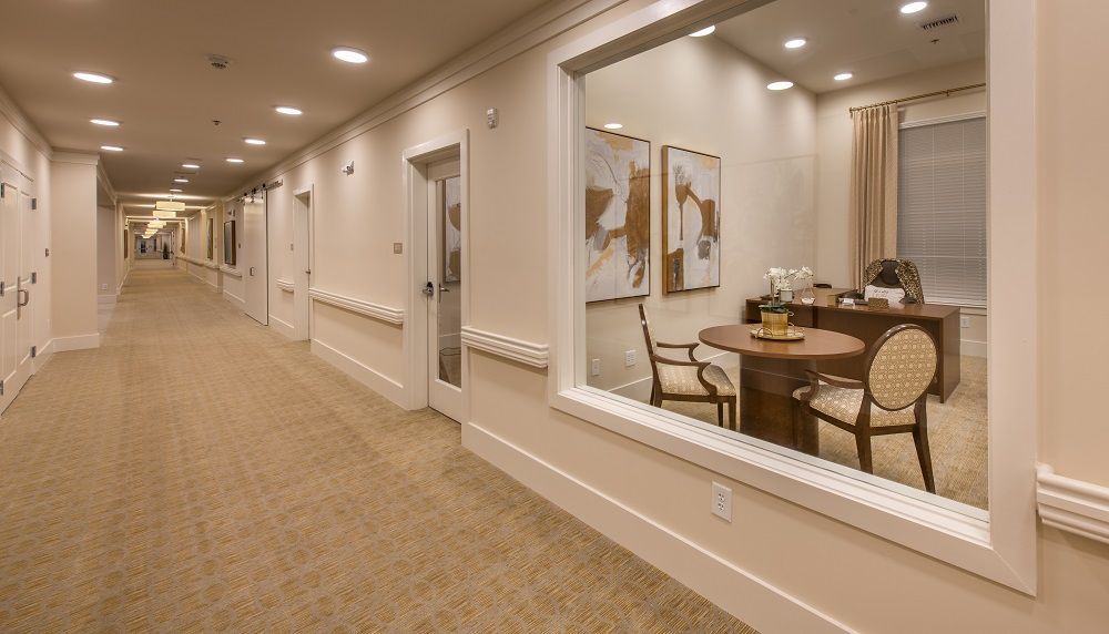 A long hallway with a table and chairs in the middle of it.