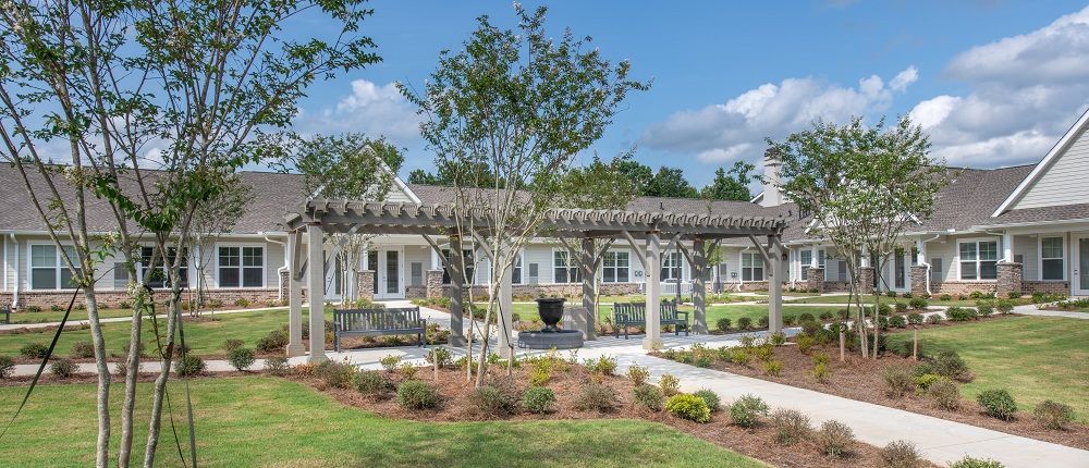 A row of houses with a pergola in the middle of the yard.