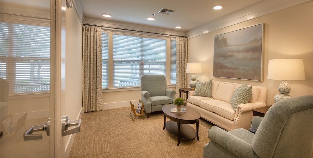 A living room with a couch , chairs , and a coffee table.