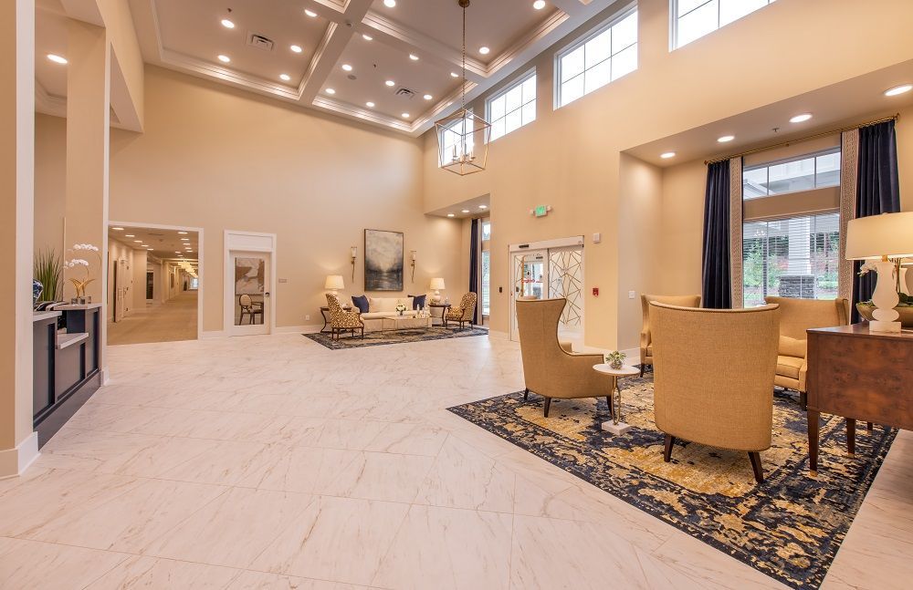 A large lobby with a lot of furniture and a piano.