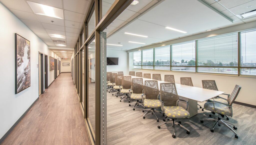 There is a long hallway leading to a conference room with a long table and chairs.