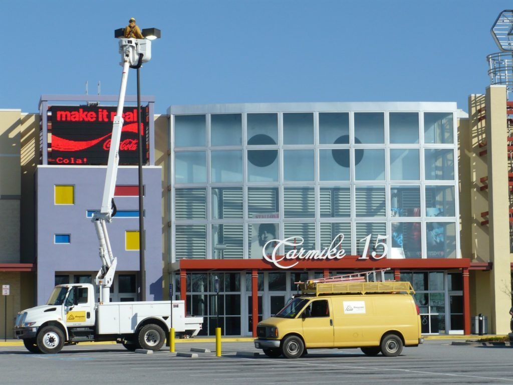 A yellow van is parked in front of a building that says carmelo 15
