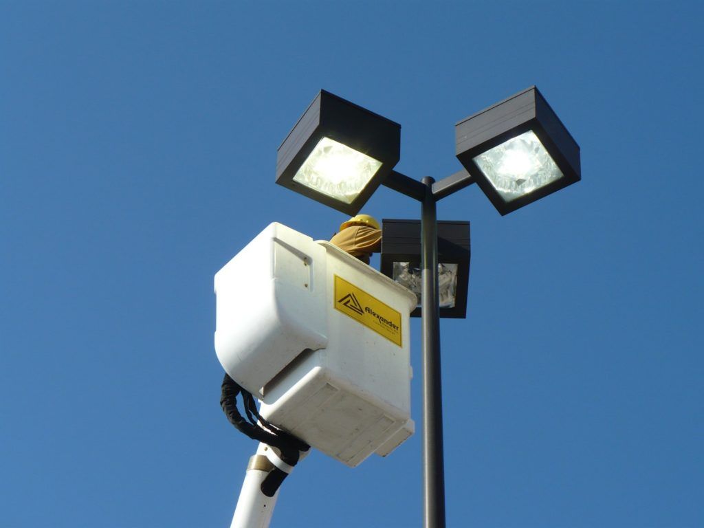 A street light with a yellow warning label on it