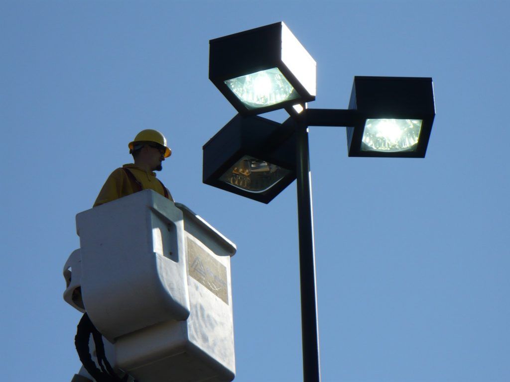A man in a bucket is working on a street light