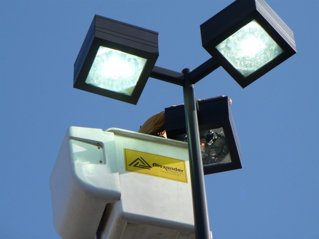 A street light with a yellow warning label on it