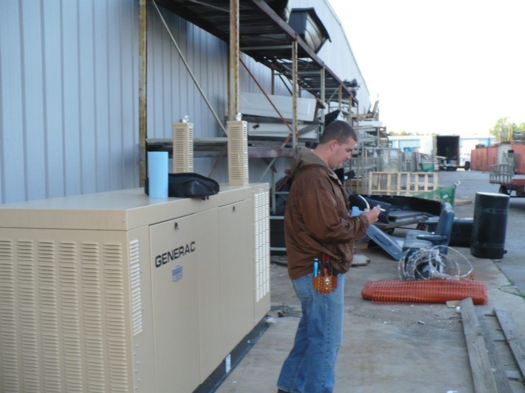 A man standing next to a generator that says generac on it