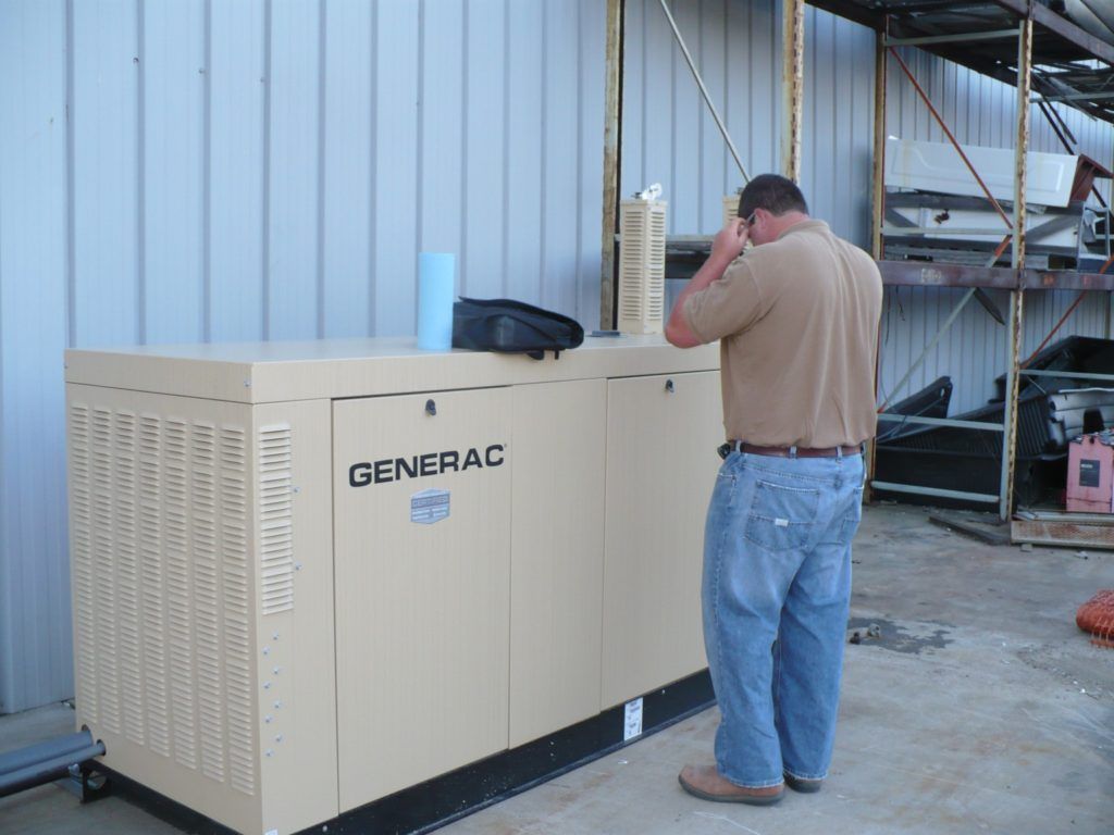 A man standing in front of a generator that says generac