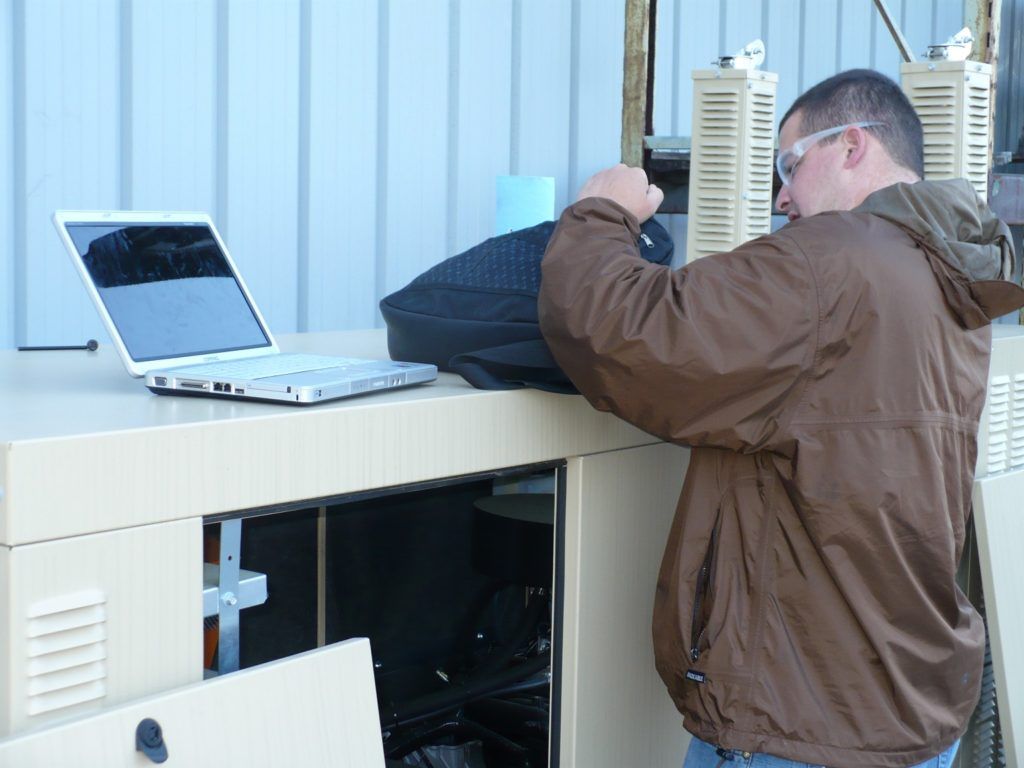 A man in a brown jacket is working on a laptop