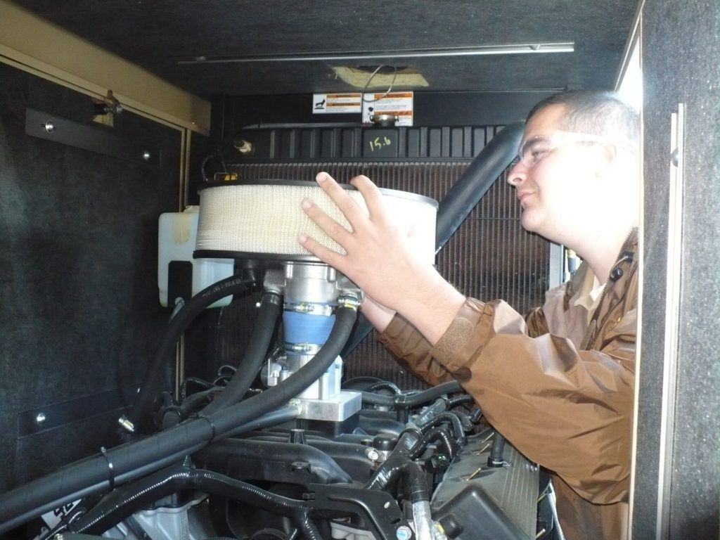 A man in a brown jacket is working on a machine