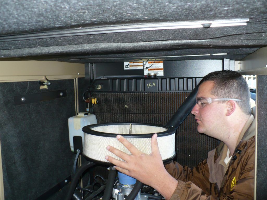 A man wearing glasses is holding a filter in his hand